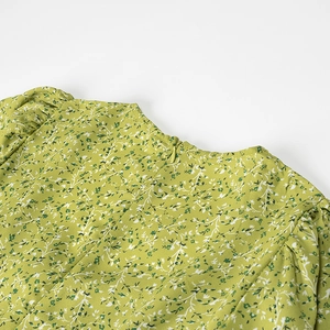 Close-up of green floral dress with invisible zipper and puff sleeve shoulder pleats