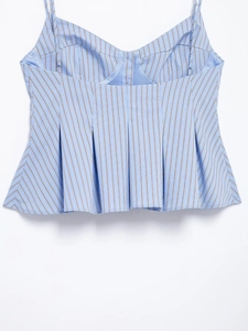 Close-up of blue and white striped peplum camisole top with v-neck and pleated hem detail