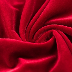 Gros plan du tissu en velours rouge avec des plis soyeux et une brillance élégante