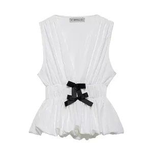 White V-neck sleeveless peplum top with textured jacquard and black satin bows