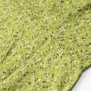 Close-up of green floral fabric showing fine stitching and lightweight texture details