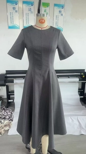 Détail de la robe grise avec taille plissée montrant la coupe ajustée et élégante