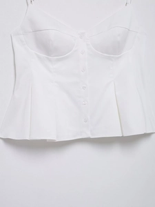 Detailed shot of white cotton corset top featuring structured cups and buttoned front bodice
