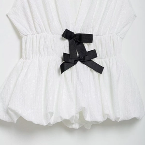 White textured dress featuring elasticated waist detail and black contrast bows