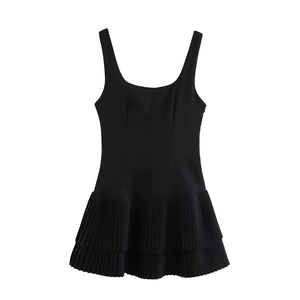 Close-up of black sleeveless mini dress with square neckline and layered pleated hem detail