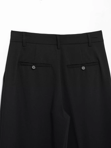 Detail of the high-waisted back design of black trousers with buttons and belt loops
