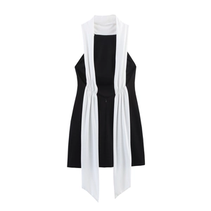 Détail de la robe moulante noire avec des lanières blanches en mousseline et des plis