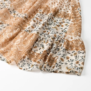 Detail view of bohemian dress with paisley print patterns and layered ruffle hem