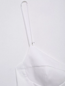 Close-up of white poplin top featuring adjustable spaghetti straps and structured stitching