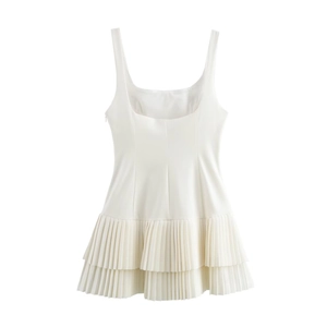 Detail of white sleeveless mini dress featuring double-layered accordion pleated hemline
