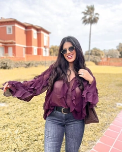 Close-up detail of layered ruffles and sheer dark purple chiffon fabric on women's blouse