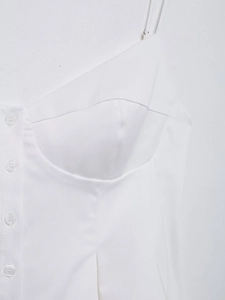 Detail view of white cotton poplin top featuring corset-style seams and button front