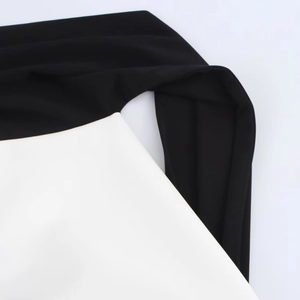 Détail de couture contrastée noire et blanche sur tissu de robe en maille élastique