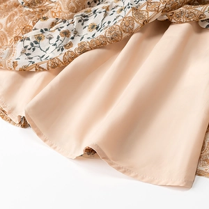 Detail view of floral print dress hem featuring bohemian patterns and pink lining
