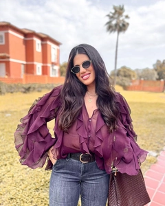 Detail of ruffled sleeves and tiered chiffon texture on dark purple V-neck blouse