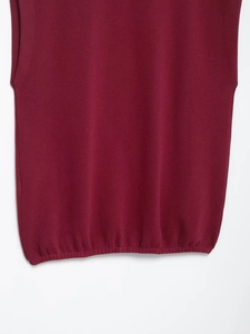 Detail view of burgundy knit sleeveless top showing fine stitch texture and ribbed hem