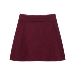Detail view of burgundy knitted mini skirt featuring ribbed waistband and A-line silhouette