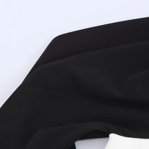 Détail de tissu noir de haute qualité montrant le contraste des textures mates et lisses