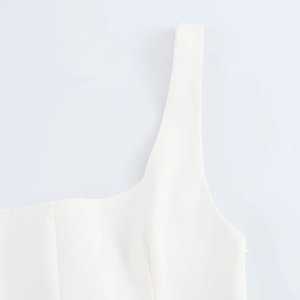 Detailed view of white mini dress featuring a classic square neckline and twill fabric texture
