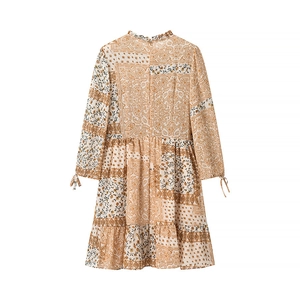 Detail of bohemian paisley print dress with ruffled high neck and tiered cake skirt hem