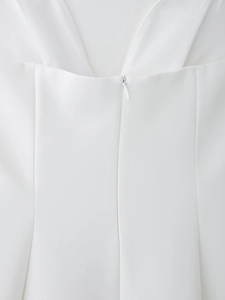 Vue détaillée d'une fermeture éclair invisible sur une robe blanche à col en V
