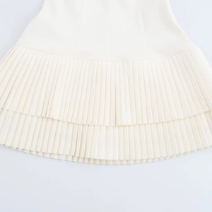 Detail of white pleated short dress featuring high-quality layered ruffle hemline
