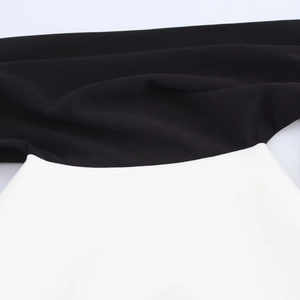 Gros plan détaillé des coutures contrastées noir et blanc sur la robe courte