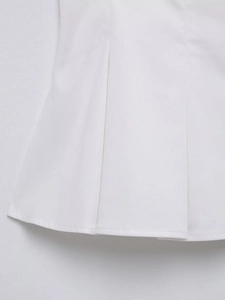 Detailed close-up of white pleated poplin hem with precise stitching and fabric texture
