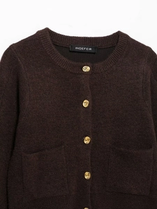 Close-up of dark brown knit cardigan texture with detailed gold spiral buttons