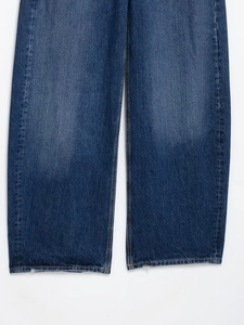 Gros plan sur le denim bleu foncé délavé vintage de ce jean large pour femme