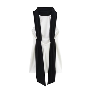 Détail du nœud de cou noir élégant sur une robe courte blanche sans manches chic