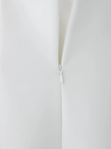 Gros plan sur la fermeture éclair invisible de haute qualité d'une robe blanche à col en V