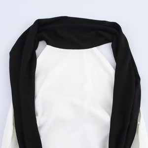Détail du col contrasté noir et blanc sur une robe courte minimaliste à nouer