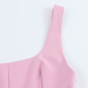 Macro detail of pink dress showing wide shoulder straps and textured woven fabric