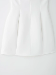 Détail du tissu blanc lisse et des coutures verticales de la jupe à coupe évasée