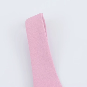 Macro shot showing the tight woven fabric texture and light pink color of the mini dress