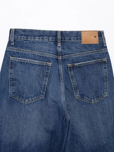 Gros plan sur un jean en denim épais de qualité avec patch cuir et double couture