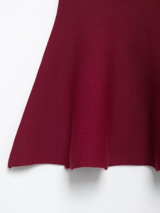 Detailed view of burgundy knit fabric texture and elegant ruffled hemline finish