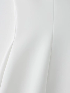 Détail des coutures nettes et du bord incurvé sur le tissu blanc de la robe à col en V
