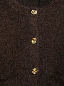 Close-up of brown knit cardigan with elegant gold metallic liquid-shaped buttons