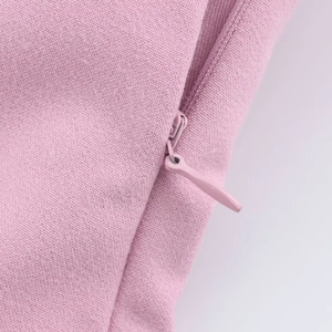 Detail of invisible zipper and woven fabric texture on pink mini dress