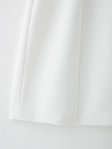 Détail du tissu tissé et des coutures fines sur l'ourlet de la robe ballon blanche épurée