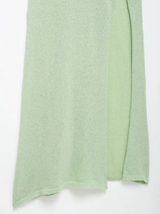 Detail view of the mint green knitted dress showing the side slit and fine fabric texture