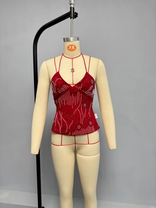Close-up of red halter top with intricate white and pink handmade beadwork and sequins