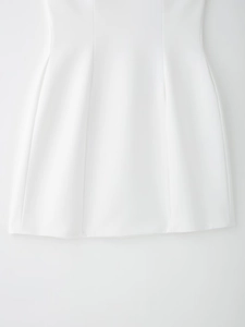 Détail des coutures verticales et de l'ourlet lisse sur une robe blanche à col en V
