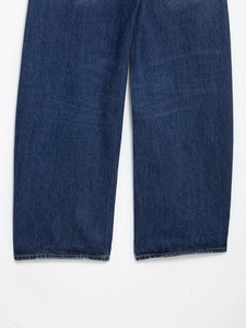 Gros plan détaillé de l'ourlet en denim bleu foncé avec double surpiqûre orange de qualité