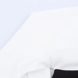 Gros plan détaillé montrant les coutures précises et le tissu haut de gamme de la robe bicolore
