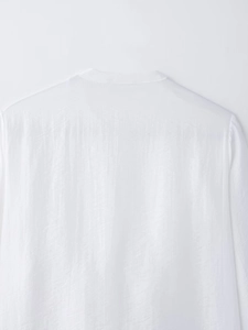 Dettaglio del colletto posteriore e delle cuciture sulle spalle di una camicia bianca