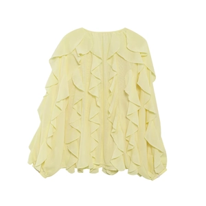 Close-up of cascading ruffles and vertical pleated layers on light yellow v-neck blouse