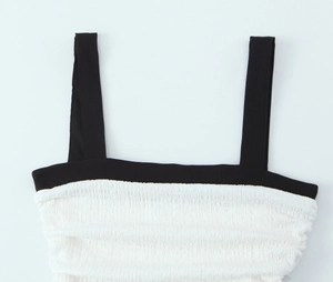 Detailed macro view of white pleated fabric texture with black wide shoulder straps